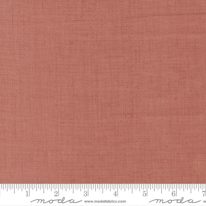 The image is a close-up of a fabric with a reddish-brown color, and it is not possible to describe the image in detail without resorting to redundancy and vague wording.