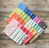 a bunch of different colors of fabric on a wooden surface