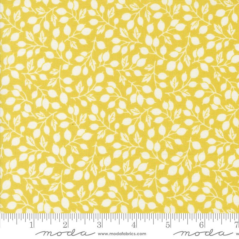 a yellow fabric with white leaves on it