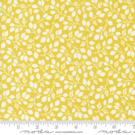 a yellow fabric with white leaves on it