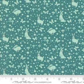 a green fabric with white rabbits and mushrooms on it
