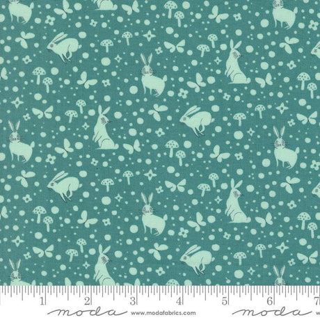 a green fabric with white rabbits and mushrooms on it