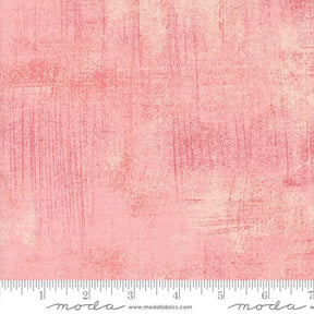 a pink background with a ruler in front of it