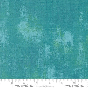 a ruler is next to a green background