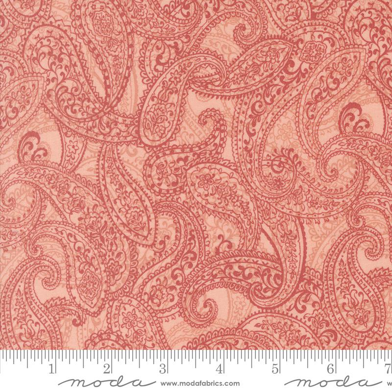 a red paisley print fabric with a ruler