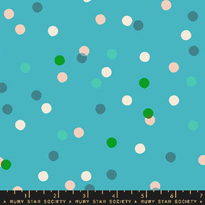 a ruler is next to a blue background with white and green polka dots
