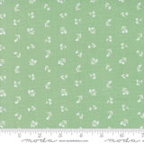 a green fabric with white flowers on it