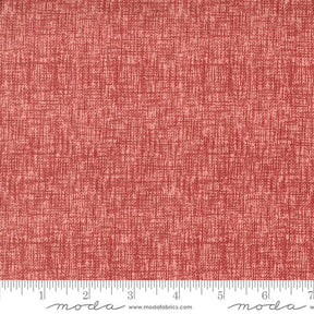 a red fabric with a ruler in front of it