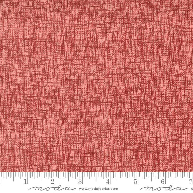 a red fabric with a ruler in front of it