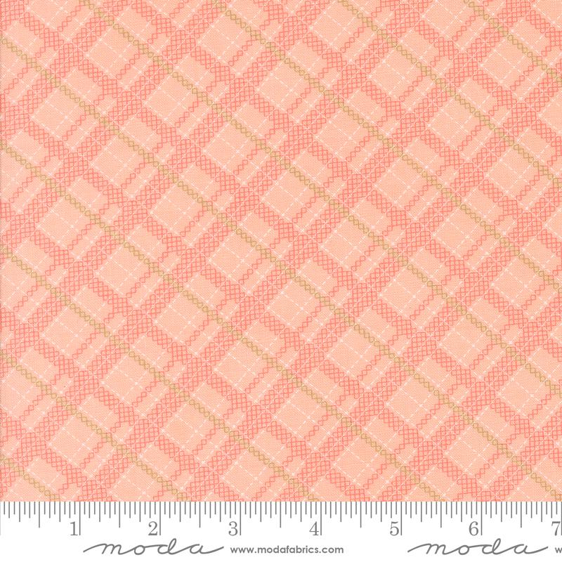 a pink and gold plaid fabric with a ruler