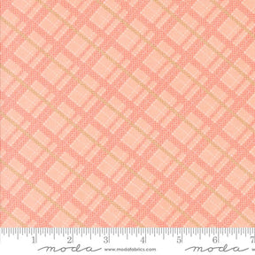 a pink and gold plaid fabric with a ruler