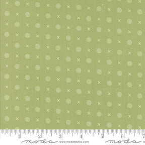 a green fabric with white circles and crosses on it