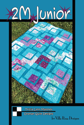 May include: A quilt pattern called '2M Junior' by Tricia Lynn Maloney for Villa Rosa Designs. The quilt is made of turquoise, pink, and purple fabric squares. The quilt is displayed on a green grassy surface.