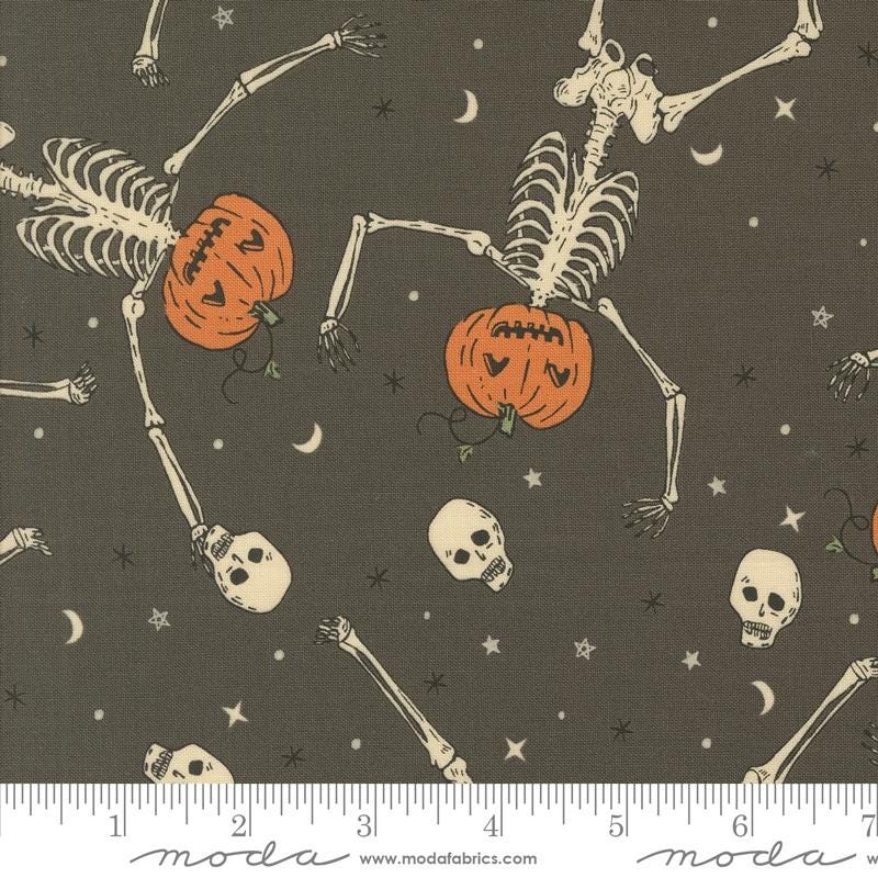 a halloween themed fabric with skeletons and pumpkins