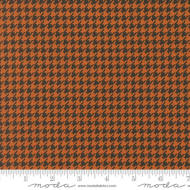 an orange and black checkered fabric with a ruler