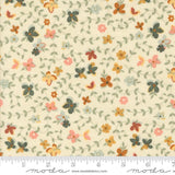 The image is a fabric with a floral pattern, featuring various shades of green, orange, and pink flowers and leaves. The fabric appears to be a light-colored material, possibly cream or pale yellow, with a repeating pattern of flowers and leaves. The image does not contain any text or specific details about the objects or their arrangement.
