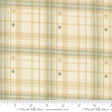 a fabric with a plaid pattern in shades of beige and green. The fabric appears to be a textile, possibly used for clothing or home decor.