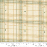 a fabric with a plaid pattern in shades of beige and green. The fabric appears to be a textile, possibly used for clothing or home decor.