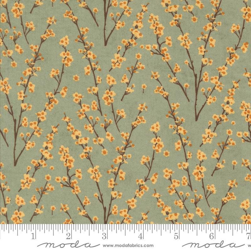 a repeating pattern of small orange flowers on brown branches against a light green background.