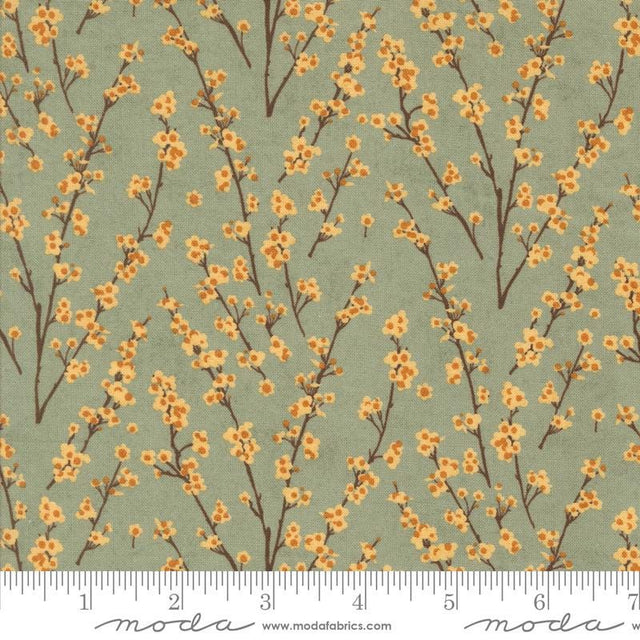 a repeating pattern of small orange flowers on brown branches against a light green background.