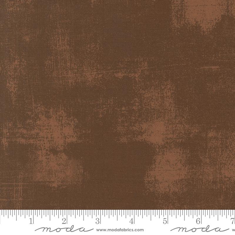 The image is a close-up of a brown fabric with a textured, distressed appearance.