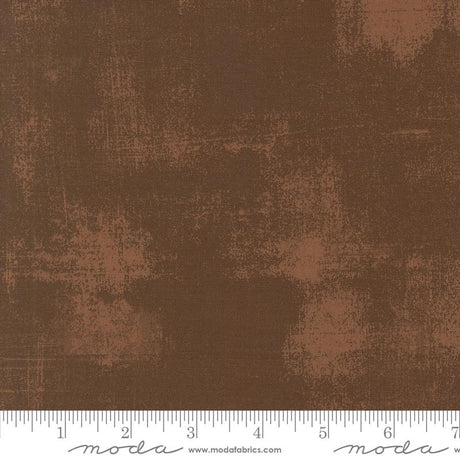 The image is a close-up of a brown fabric with a textured, distressed appearance.