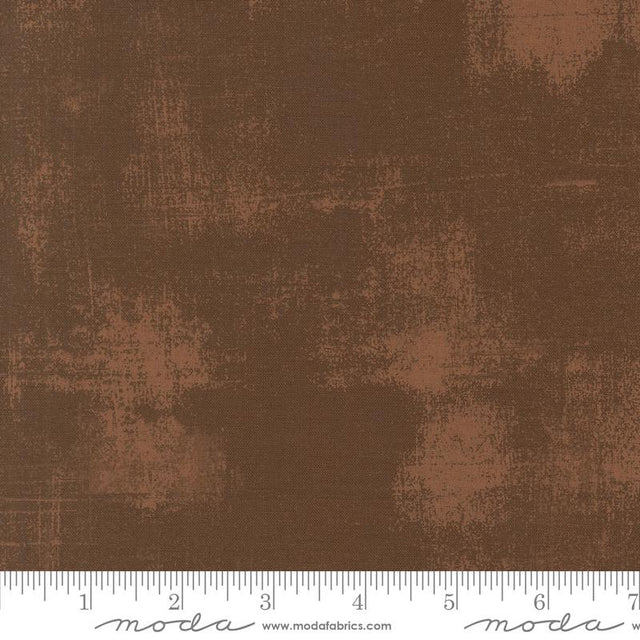 The image is a close-up of a brown fabric with a textured, distressed appearance.