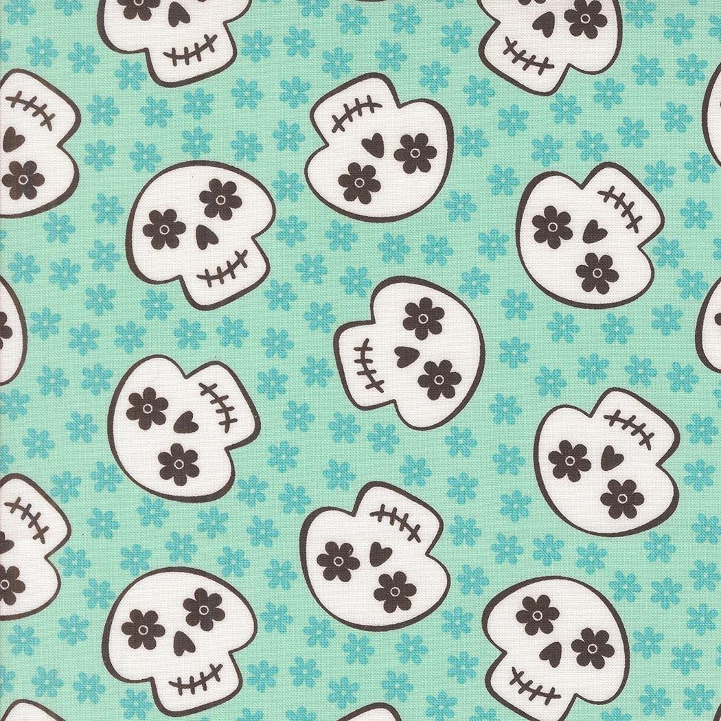 a repeating pattern of stylized white skull faces with black floral accents against a light blue background.