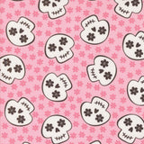 a repeating pattern of stylized skull faces on a pink background with small pink flowers scattered throughout.