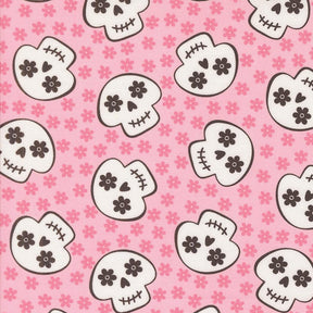 a repeating pattern of stylized skull faces on a pink background with small pink flowers scattered throughout.