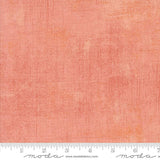 The image is a close-up of a textured fabric with a gradient of peach and orange colors.
