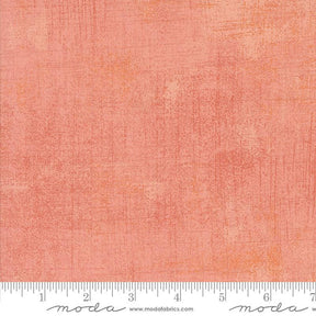 The image is a close-up of a textured fabric with a gradient of peach and orange colors.