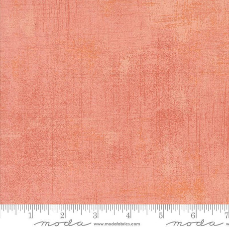 The image is a close-up of a textured fabric with a gradient of peach and orange colors.