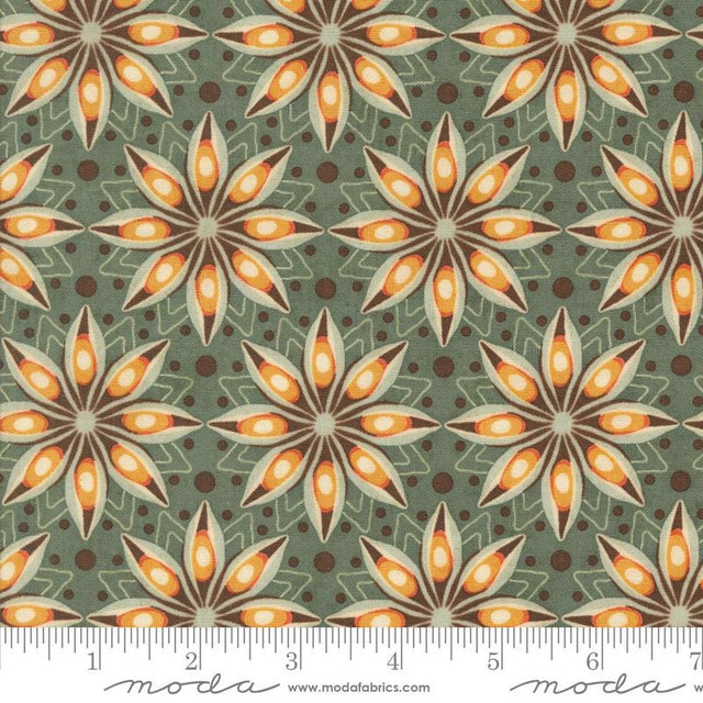 a repeating pattern of stylized orange and brown flowers on a green background, with a ruler for scale.