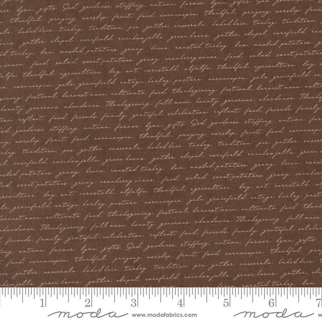 a brown fabric with a repeating pattern of cursive text, which appears to be a printed design. The text is not uniform and varies in size and style, creating a visually interesting and textured appearance.