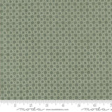 a close-up view of a fabric with a repeating pattern of green circles on a white background.