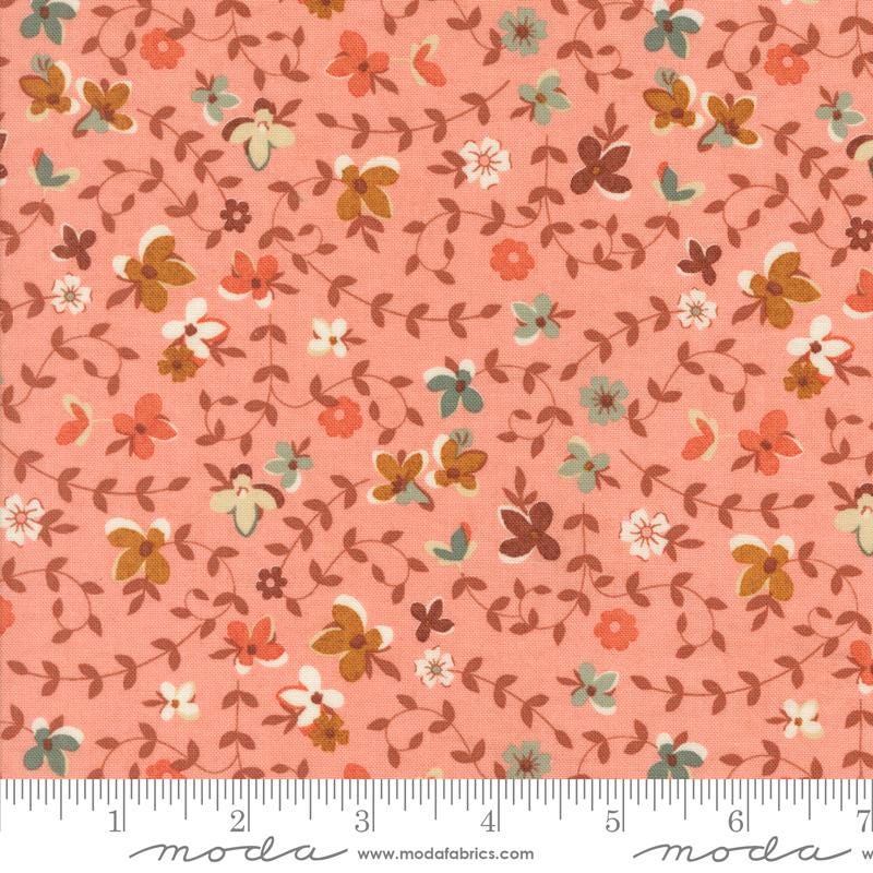 The image is a fabric with a floral pattern in shades of pink and orange. The pattern consists of various flowers and leaves in different colors, creating a visually appealing and textured design.