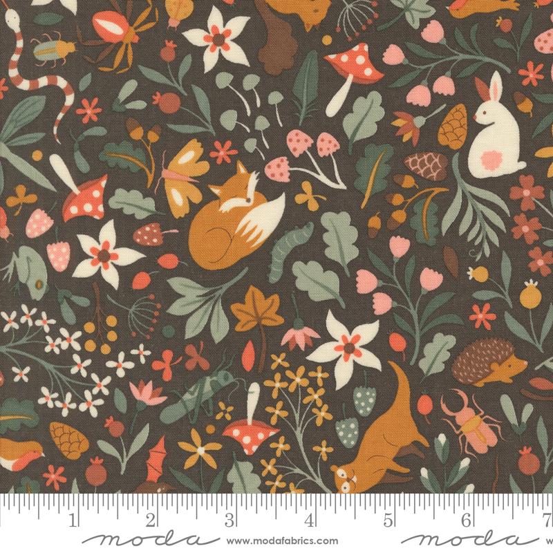 The image is a vibrant and colorful fabric with a variety of animals, flowers, and mushrooms printed on it. The pattern includes a rabbit, a fox, a hedgehog, and other woodland creatures, as well as various types of flowers and mushrooms. The fabric appears to be a part of a larger textile or garment, with a ruler visible in the bottom right corner for scale.