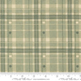 a fabric with a green and beige plaid pattern, featuring a repeating diagonal grid-like design. The fabric appears to be a textile or material with a plaid pattern, which is a type of textile design characterized by diagonal or crisscrossing lines. The fabric is displayed on a ruler for scale, indicating its size or dimensions.