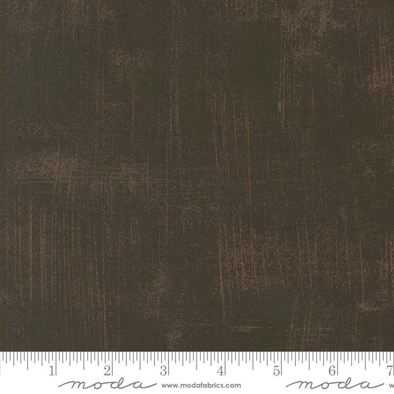 The image is a close-up of a textured fabric with a dark brown or black color.