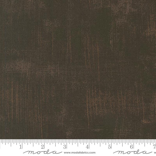 The image is a close-up of a textured fabric with a dark brown or black color.