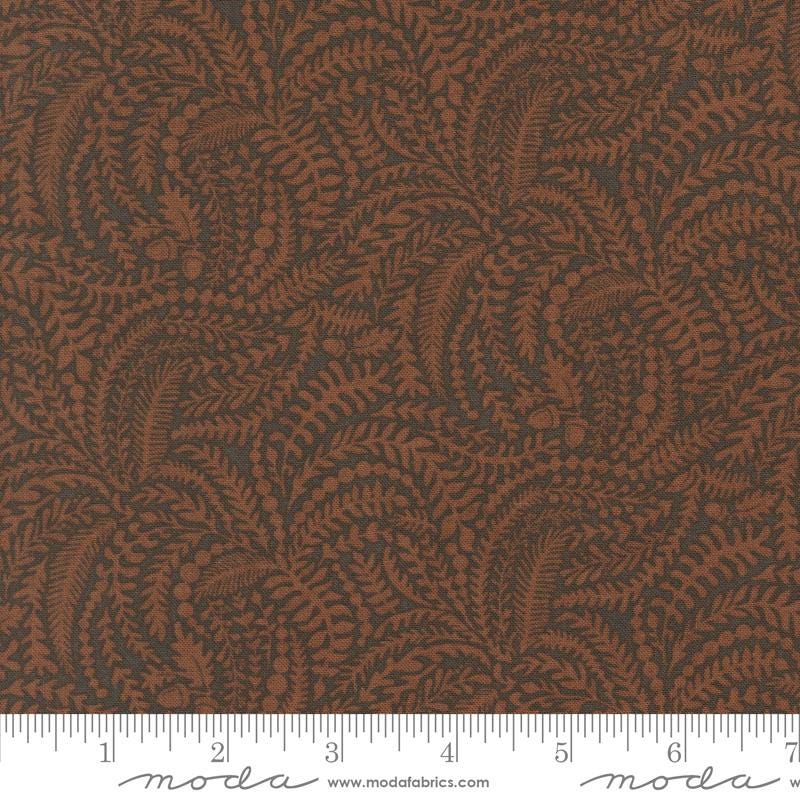 a close-up view of a fabric with a repeating pattern of brown leaves and branches, creating a textured and visually interesting design.