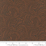 a close-up view of a fabric with a repeating pattern of brown leaves and branches, creating a textured and visually interesting design.