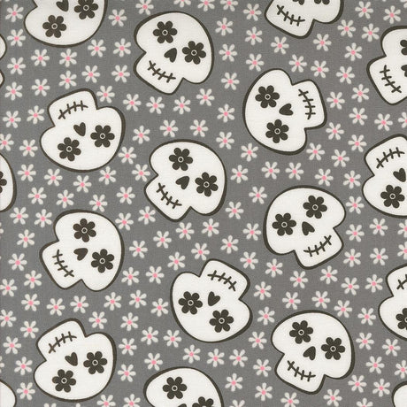 a repeating pattern of black and white skull faces against a gray background with small white flowers scattered throughout.