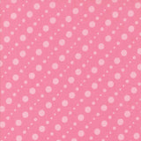 a pink background with white polka dots arranged diagonally across the frame.
