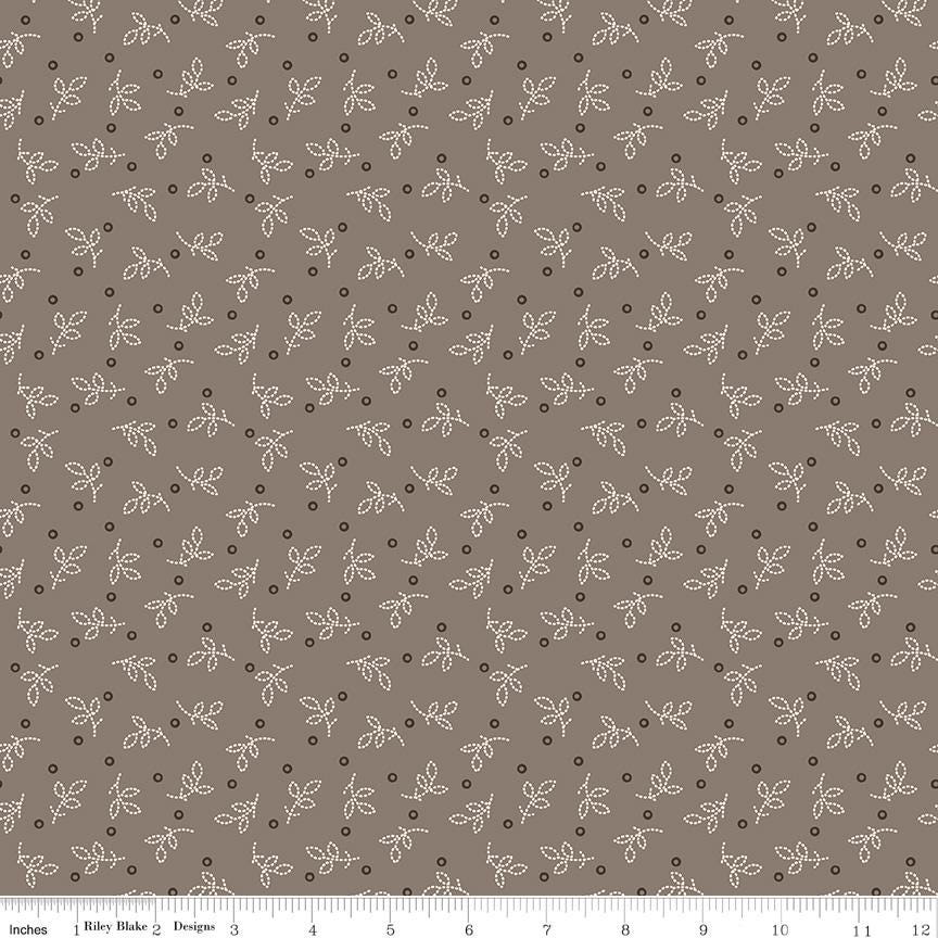 a repeating pattern of small white dots and leaf-like shapes on a brown background.
