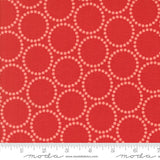 a close-up view of a red fabric with a repeating pattern of white circles on it. The fabric appears to be a fabric with a bold, geometric design.