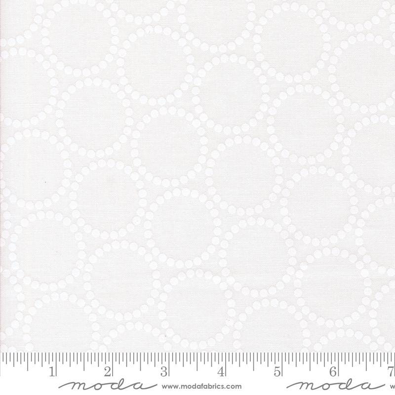 The image is a fabric with a repeating pattern of white circles or dots, creating a visually cohesive design.