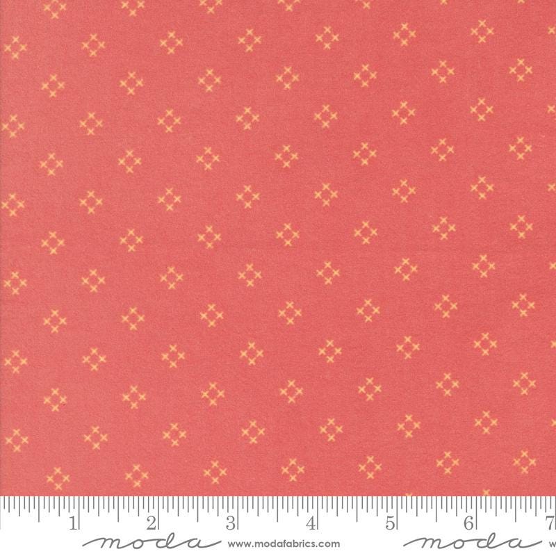 a red fabric with small yellow diamond-shaped patterns evenly distributed across it.