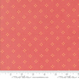 a red fabric with small yellow diamond-shaped patterns evenly distributed across it.